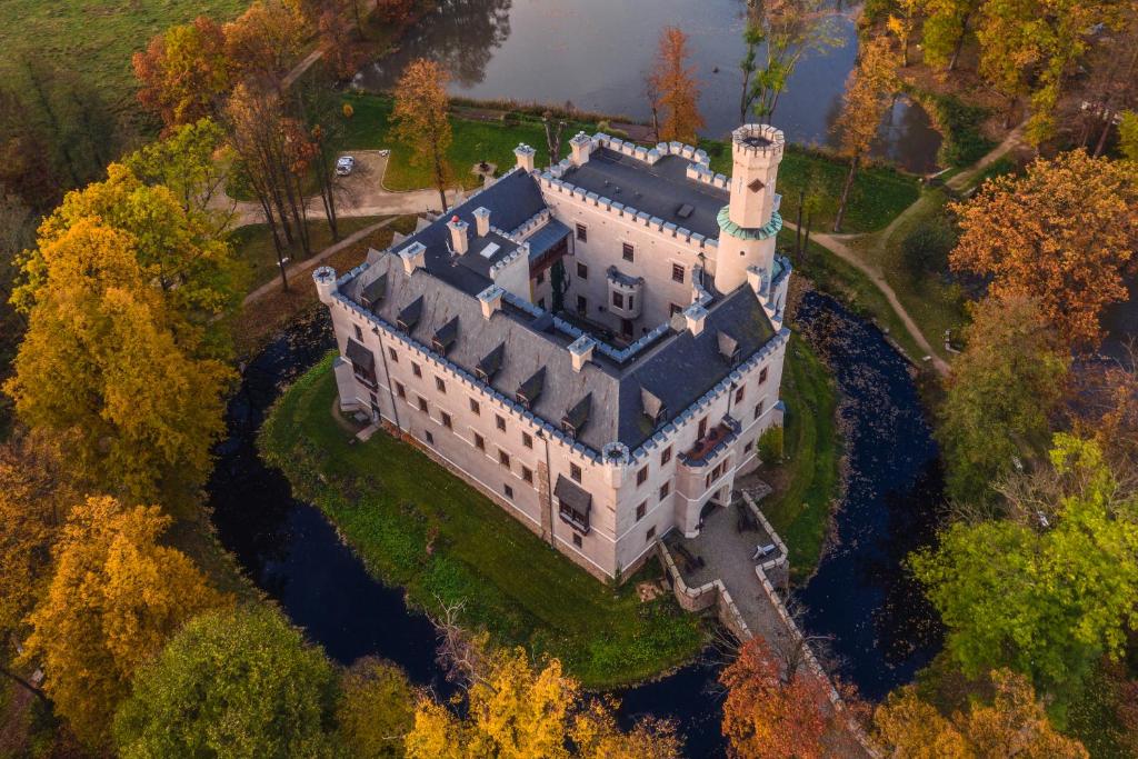 una vista aérea de un castillo en los árboles en Zamek Karpniki Schloss Fischbach, en Łomnica