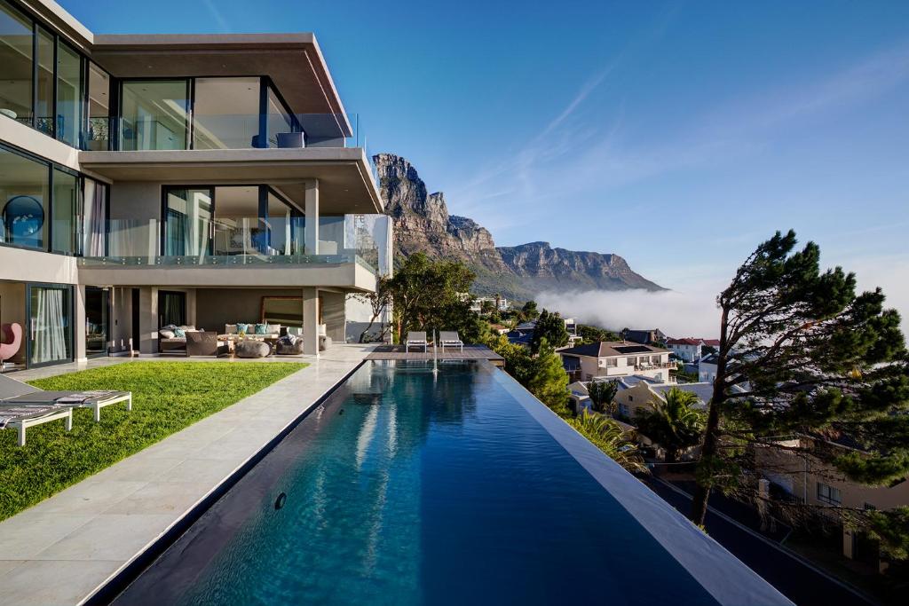 a house with a swimming pool in front of a mountain at CB-ONE Luxury Stay in Cape Town