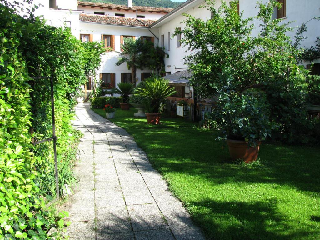een tuin met bomen en planten in een gebouw bij Albergo Ristorante Borghese in Montereale Valcellina