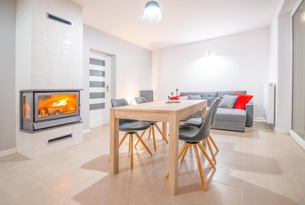 a living room with a table and a fireplace at Apartament Czarna Wieś in Rajgród