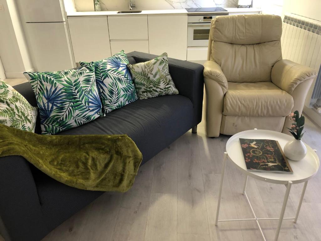 uma sala de estar com um sofá preto e uma cadeira em CHESS CITY em Salamanca