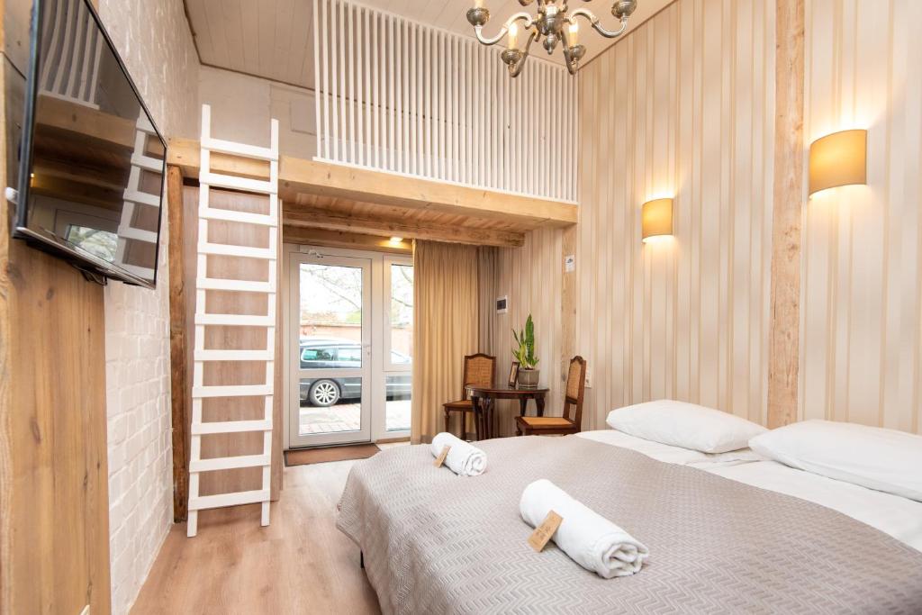 a bedroom with a bed with two towels on it at KUBU Loft in Klaipėda