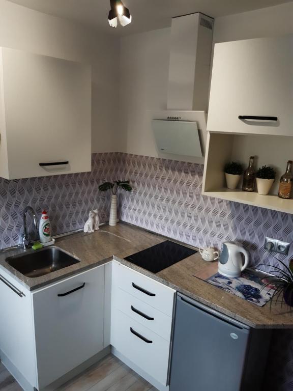 a kitchen with white cabinets and a sink at Apartament Teo -Rewal in Rewal