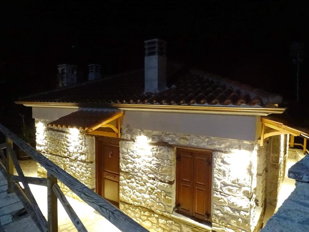 uma casa com luzes de lado à noite em Τείχιο Πατρικό - Tihio Patriko - Πέτρινη κατοικία em Tíkhion