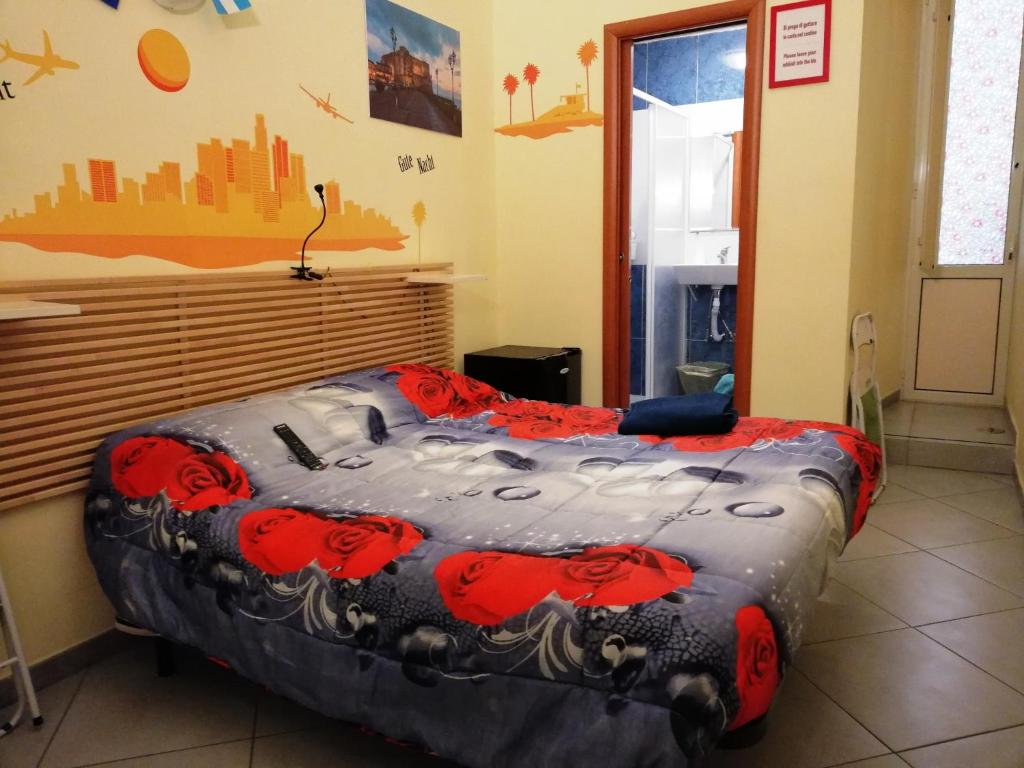 ナポリにあるB&B Da Robertoのベッドルーム1室(赤い花のベッド1台付)