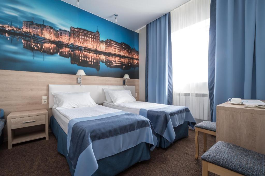 una habitación de hotel con 2 camas y un cuadro en la pared en North Crown Hotel, en Víborg