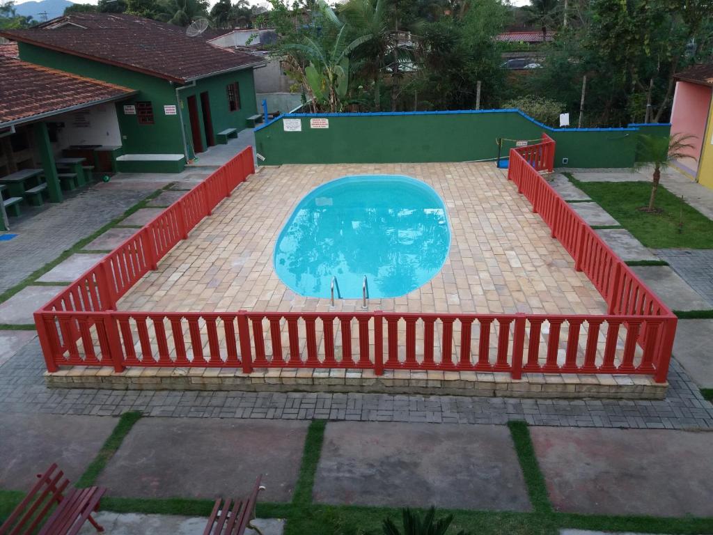 a swimming pool with a red fence around it at Chalés Bandeiras in Ubatuba