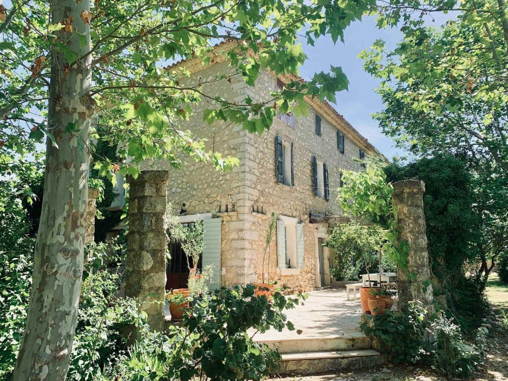 een oud stenen gebouw met bomen ervoor bij La Bastide in Saint-Julien