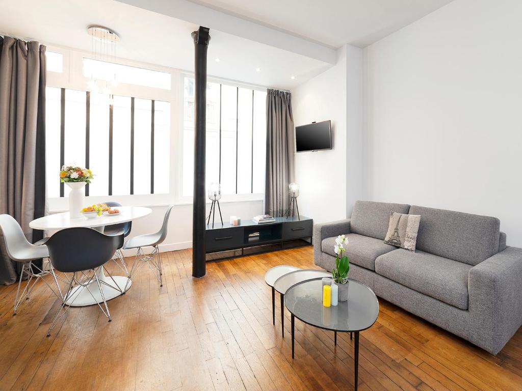 a living room with a couch and a table at Studios de Charme à Montmartre in Paris