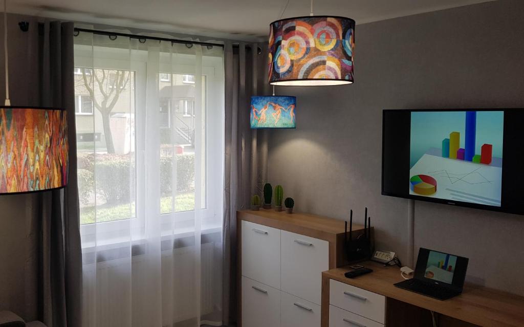 a living room with a tv and a window at Arena Studio in Gliwice