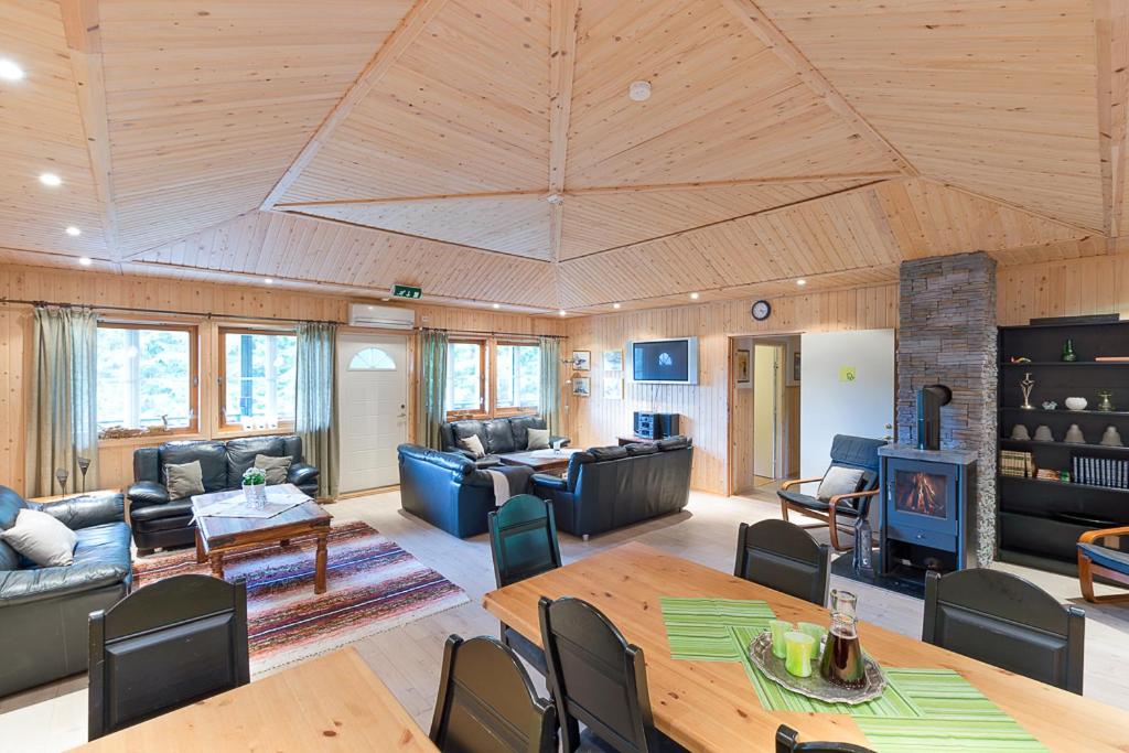 a living room with a wooden ceiling and a table at Trysil Motell & Vandrerhjem in Trysil
