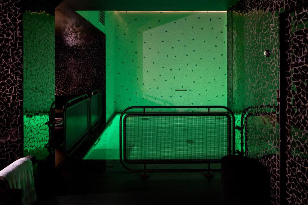 a green room with a tub in a bathroom at Hotel Les Bains Paris in Paris