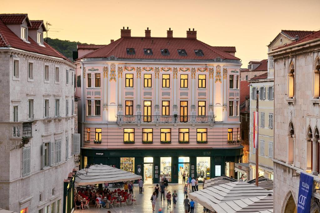 um grande edifício com pessoas andando na frente dele em Piazza Heritage Hotel em Split
