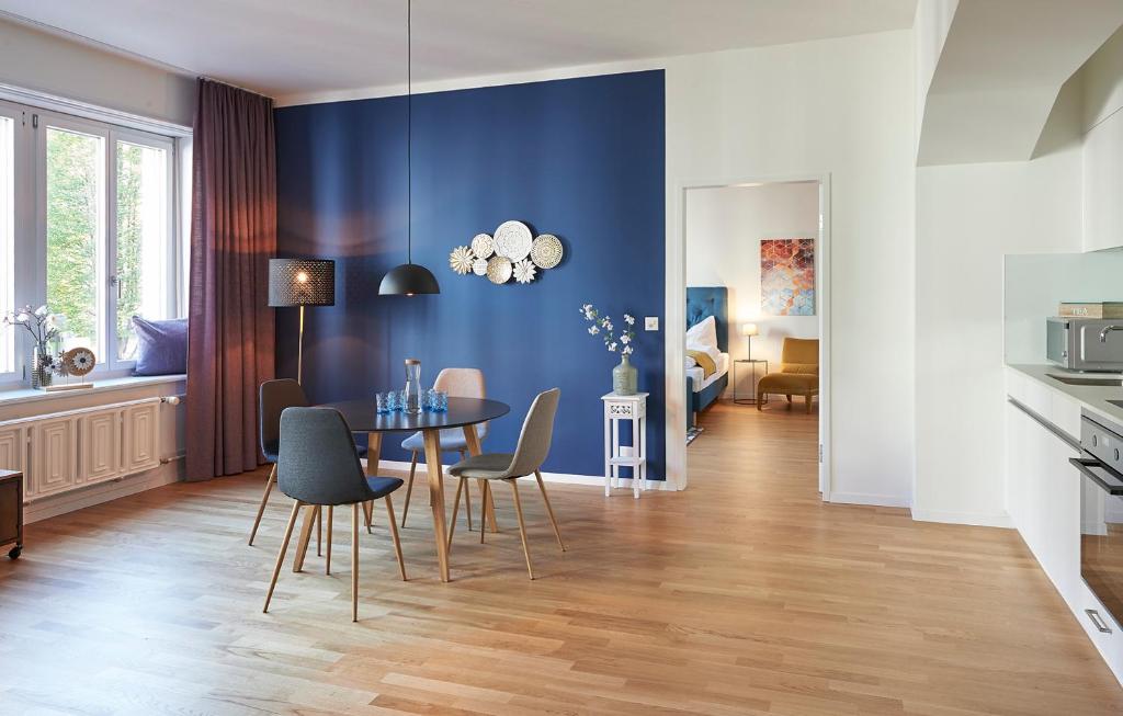 comedor con paredes azules, mesa y sillas en Neustadt Apartments managed by Hotel Central Luzern, en Lucerna