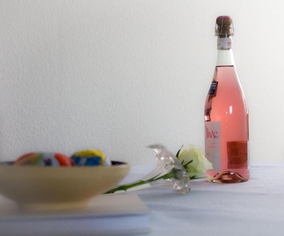 eine Flasche Wein auf einem Tisch neben einer Schüssel in der Unterkunft Ferienwohnungen Neue Tiefe - Wohnung Kleiderbügel in Neue Tiefe Fehmarn