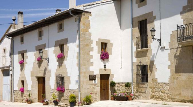 a white building with flowers on the side of it at Casa Rural Lakoak in Garínoain