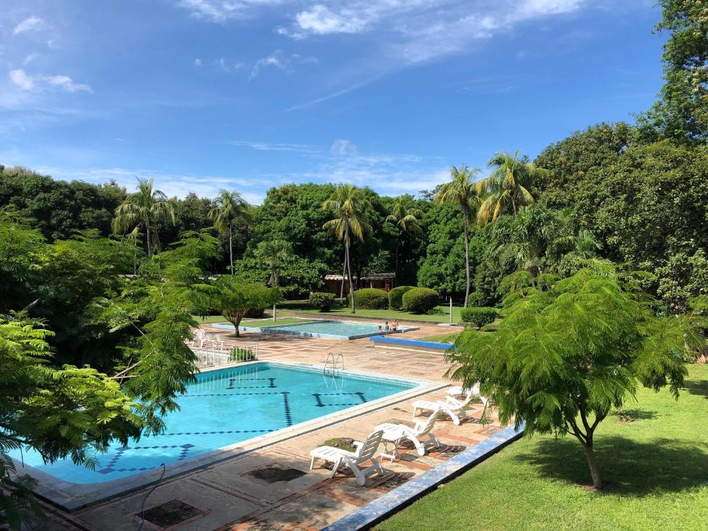 vistas a una piscina con sillas y árboles en Hotel Diriá Santa Cruz, en Santa Cruz