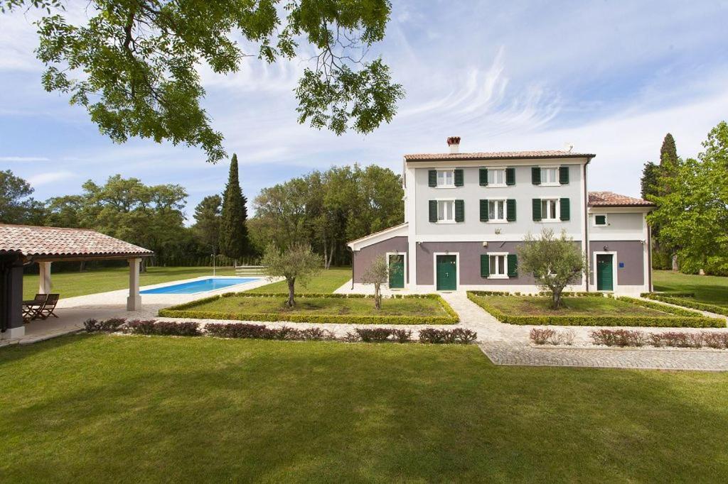 a large white house with a yard and a pool at Villa Rustica in Fondole