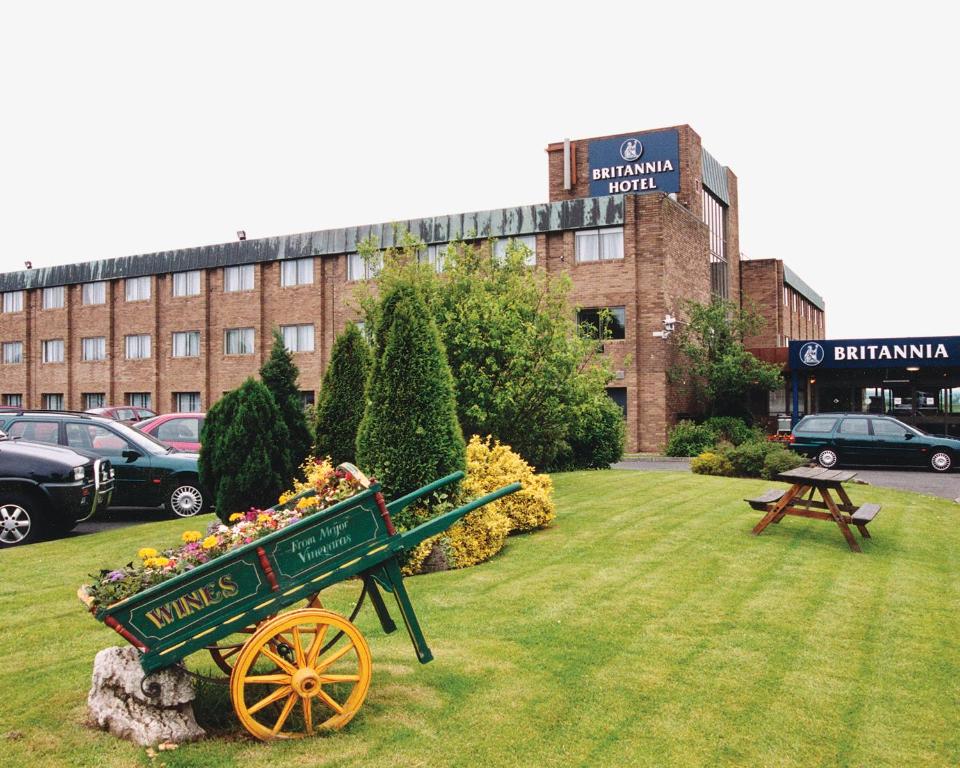 a garden with a green wagon in the grass at Britannia Hotel Newcastle Airport in Newcastle upon Tyne