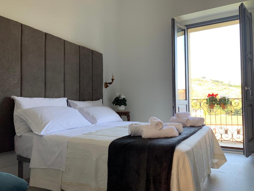 a bedroom with a large bed with towels on it at Palazzo Samà in Catanzaro