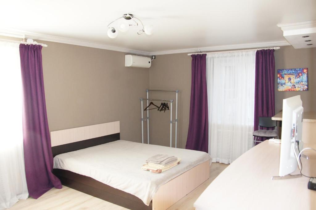 ノヴォロシースクにあるстудияのベッドルーム1室(紫色のカーテン付きのベッド1台付)