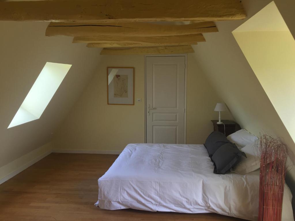 a bedroom with a white bed in a attic at Maison en Périgord à 5 mn à pieds du centre Sarlat in Sarlat-la-Canéda
