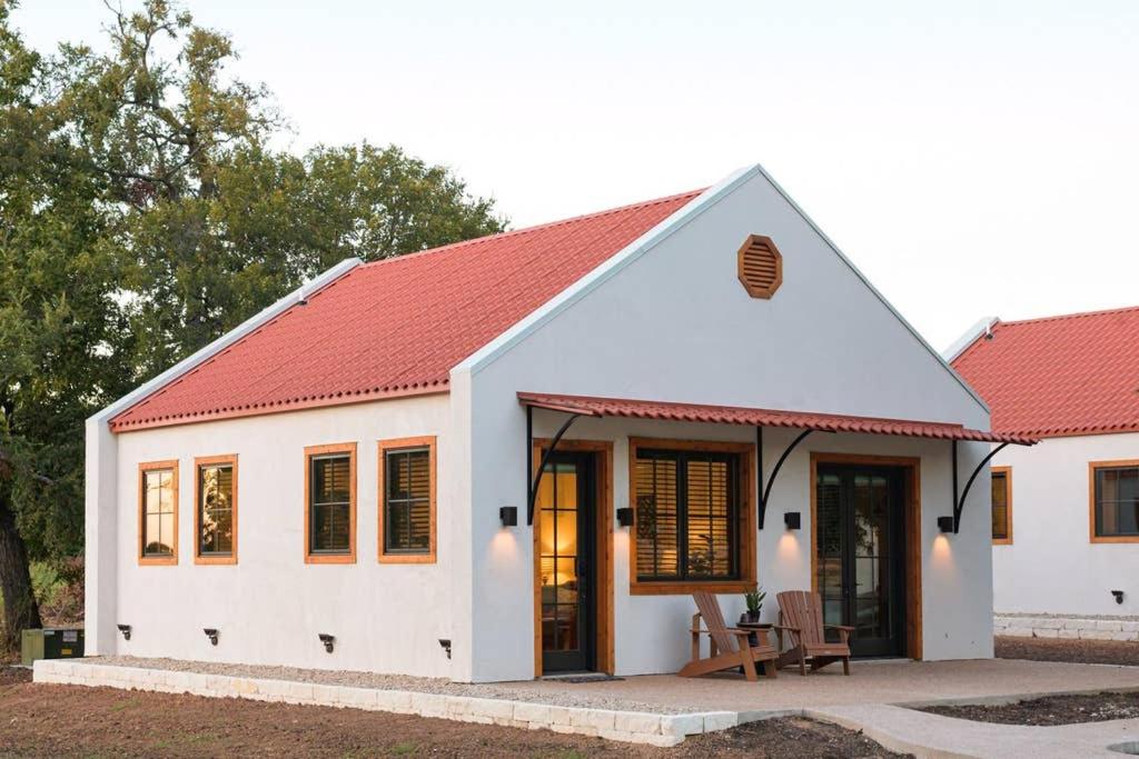 een wit huis met een rood dak bij Little Dutch Cabin #1 - 12 min to Magnolia-Baylor in Bellmead