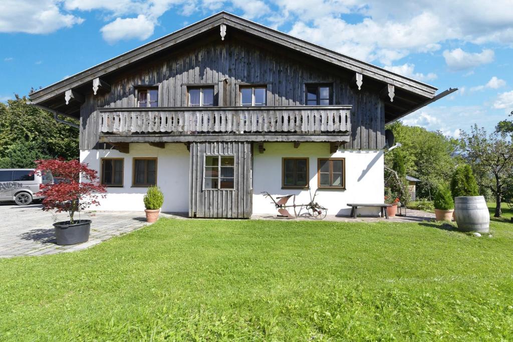 una casa con un césped verde delante de ella en Jaudenhof - Apartment Hochalm en Lenggries