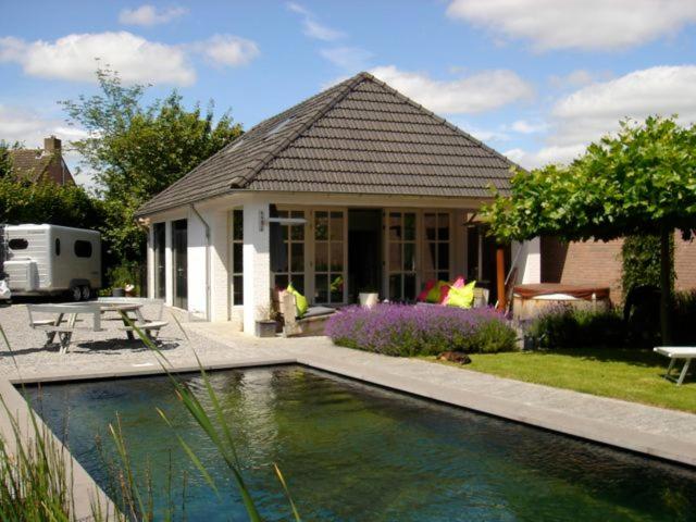 a house with a swimming pool in front of a house at Gardenhouse with private jacuzzi and sauna in Teteringen
