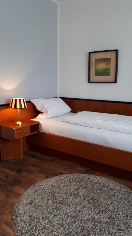1 Schlafzimmer mit 2 Betten, einer Lampe und einem Teppich in der Unterkunft Gasthof Sommer in Bösel