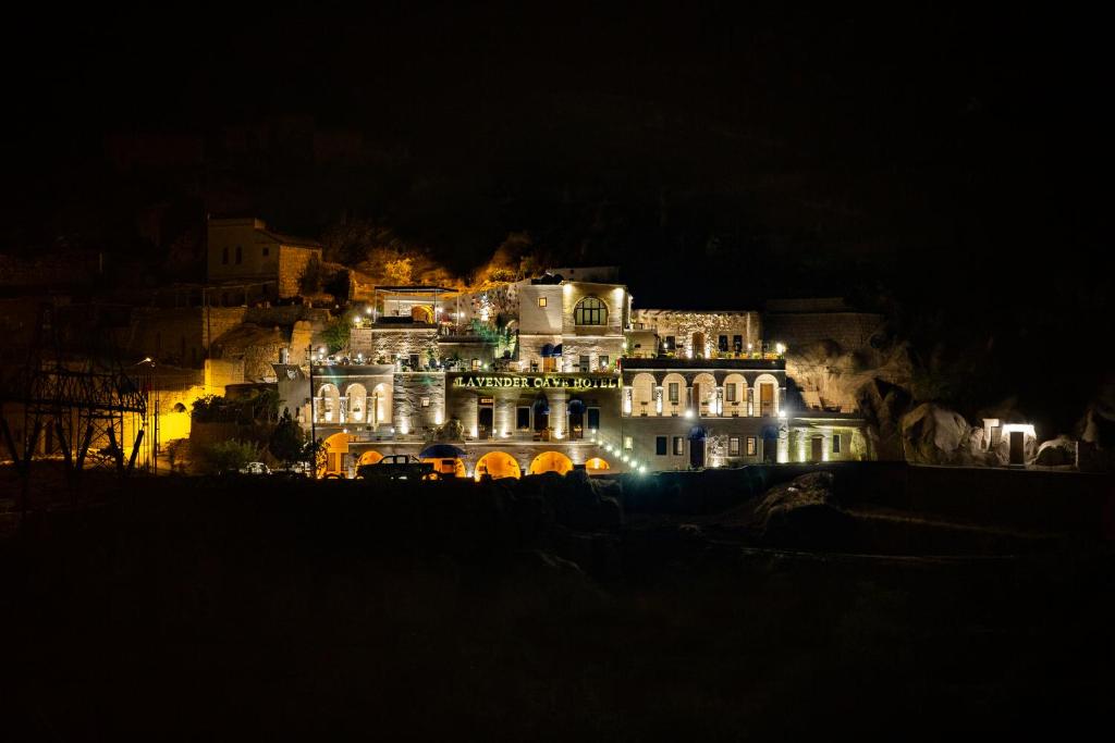 a large building on a hill at night at Lavender Cave Hotel in Nevşehir