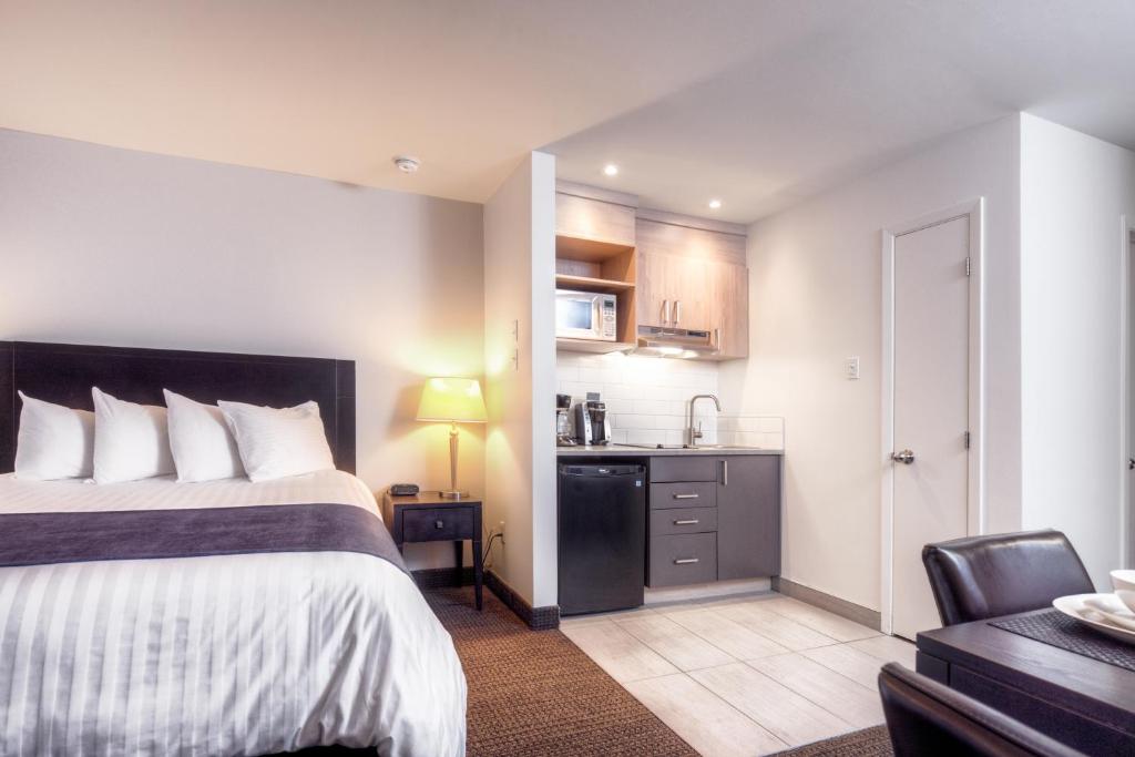 a hotel room with a bed and a kitchen at Hotel Vacances Tremblant in Mont-Tremblant