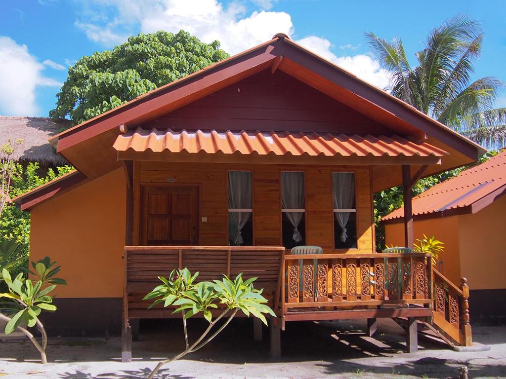 een klein huis met een veranda ervoor bij Coco Beach Bungalows in Ko Lipe