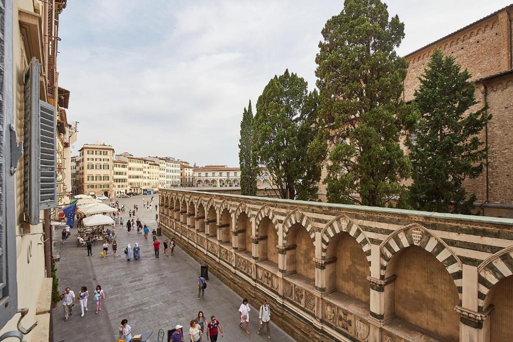 Un gruppo di persone che camminano su una strada vicino a un ponte di Casa Cosi - Maria Novella a Firenze