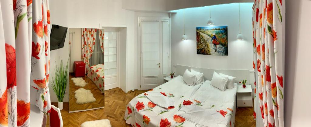 Victoria Luxury Apartment 11 في بوخارست: غرفة نوم بسرير مع شراشف بيضاء وورد احمر