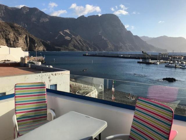balcón con mesa, sillas y vistas al agua en CasaPello TOP TERRACE, en Puerto de las Nieves