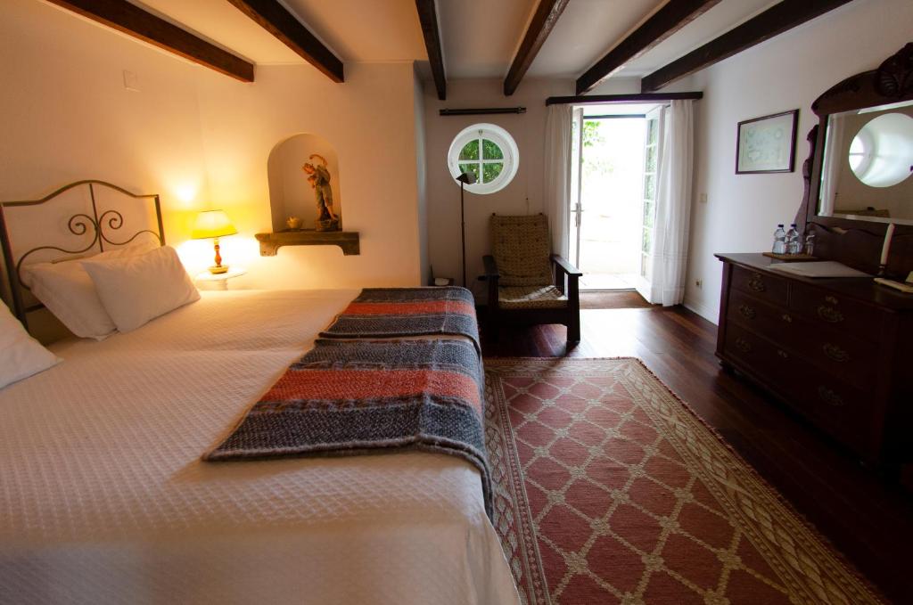 a bedroom with a large bed and a television at Quinta das Buganvílias in Castelo Branco