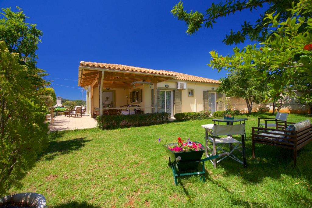 un patio con una casa con una mesa y un banco en Sunnyside House Kefalonia en Kefallonia