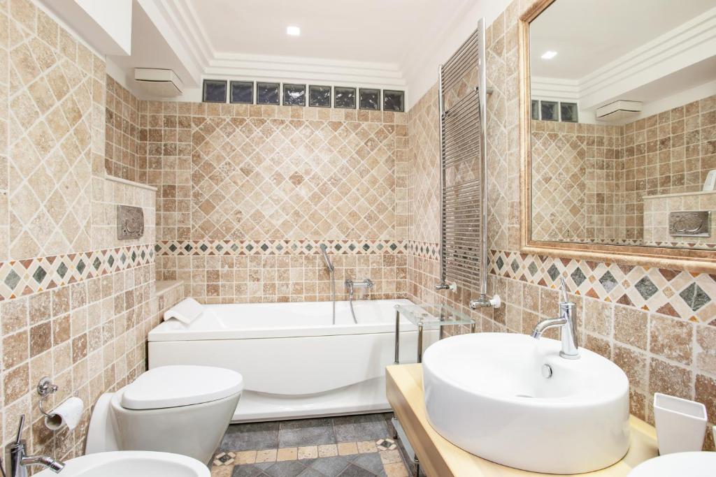 łazienka z wanną, toaletą i umywalką w obiekcie Penelope Seaview Apartment w Katanii