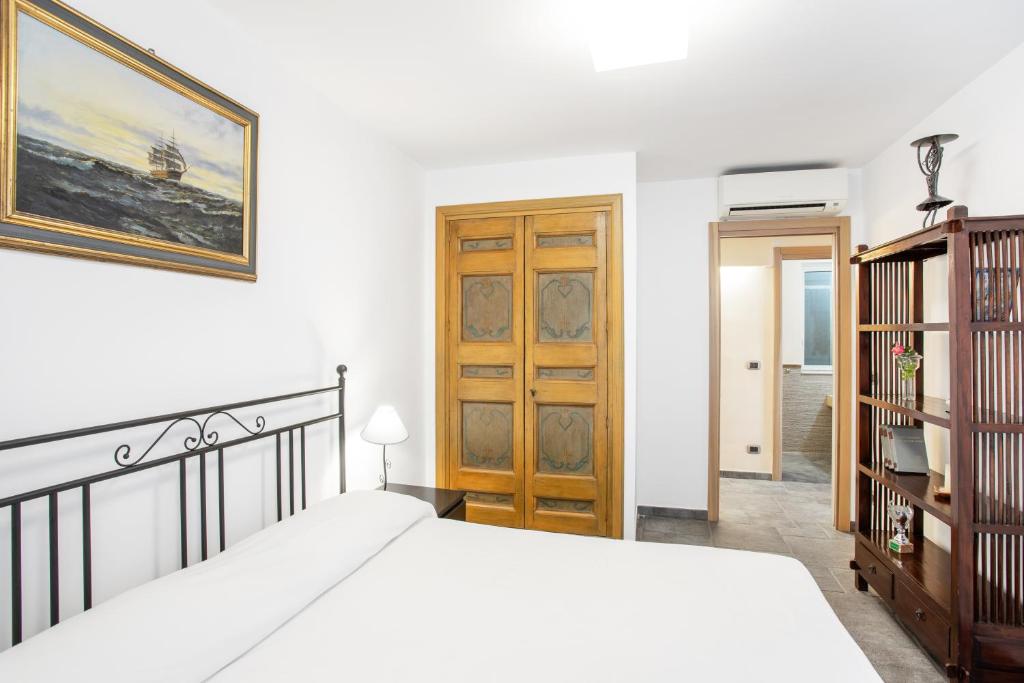 sypialnia z łóżkiem i drewnianymi drzwiami w obiekcie Penelope Seaview Apartment w Katanii