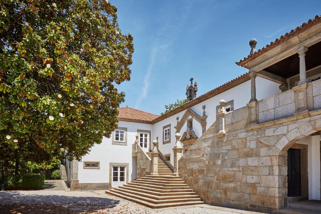 a building with stairs and a stone wall at Paço de Calheiros - Turismo de Habitação in Ponte de Lima