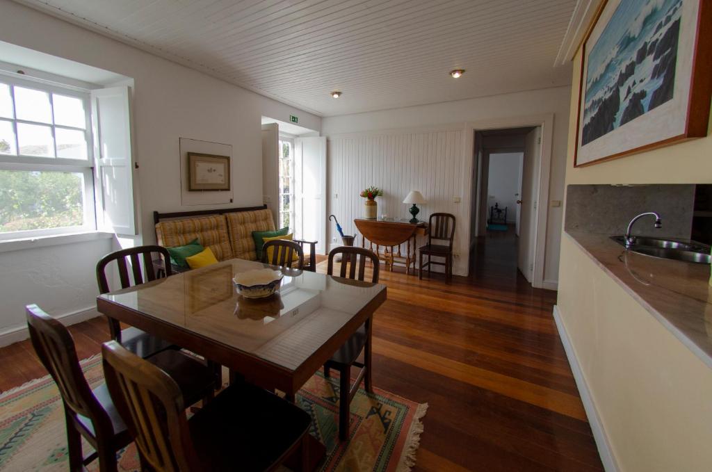 a dining room and living room with a table and chairs at Quinta das Buganvílias in Castelo Branco