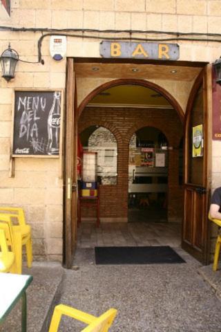 an entrance to a bar with yellow tables and chairs at Hotel Restaurante Valdevenados in Anguiano