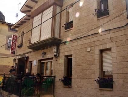 un edificio in mattoni con balcone sul lato di Hotel Restaurante Valdevenados ad Anguiano