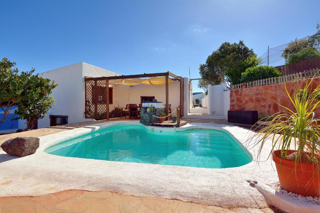 a swimming pool in the backyard of a house at BAJO EL VOLCÁN Rural Villa Canaria in Montaña Blanca