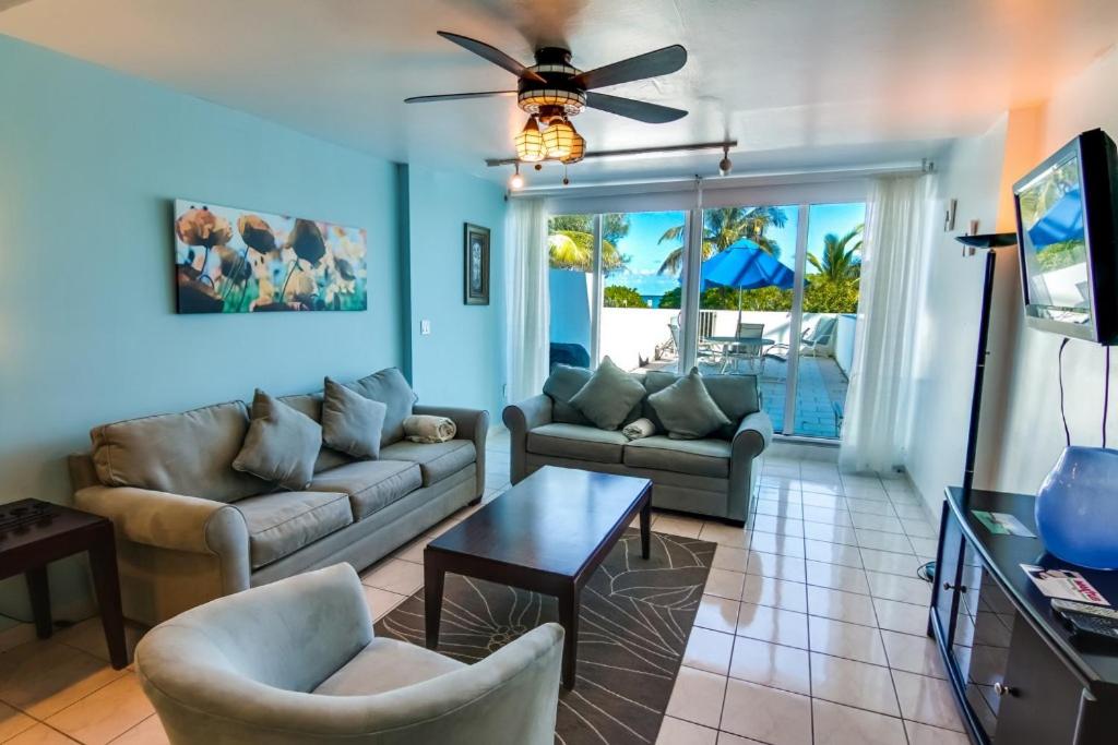 a living room with a couch and a table at Beachfront Townhouse with private patio, direct beach access, gym, bars & free parking! in Miami Beach