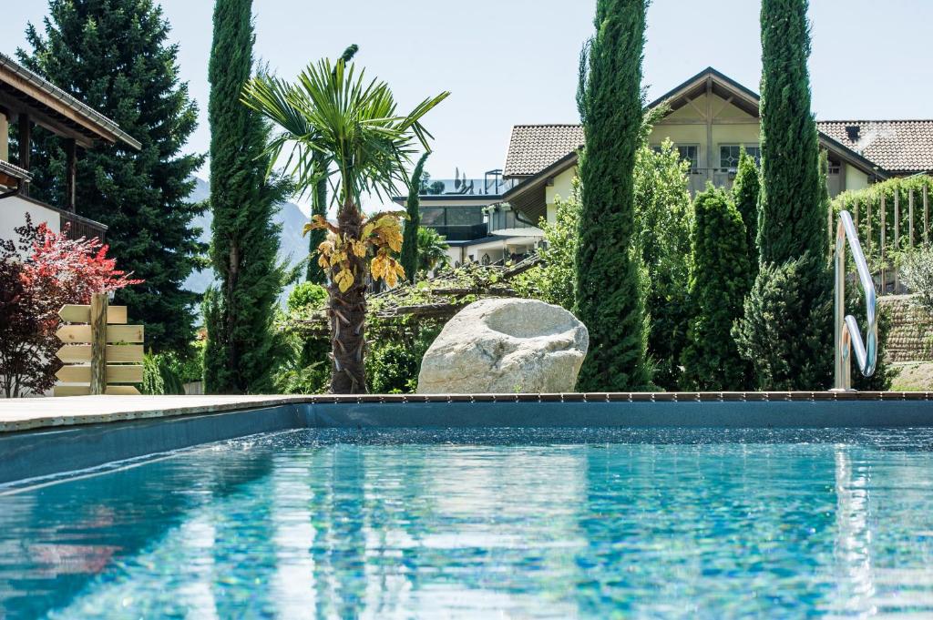 una piscina frente a una casa con árboles en Premium Apartments Faselehof, en Marlengo