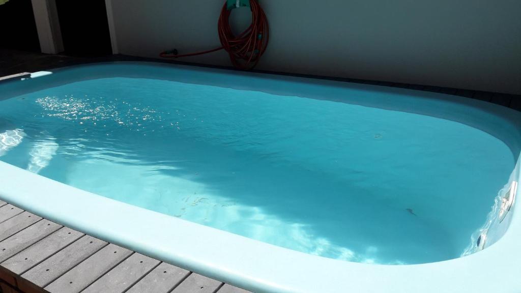 une grande baignoire bleue assise sur une terrasse en bois dans l'établissement Hostel na Rota da Serra Gaúcha, à Taquara