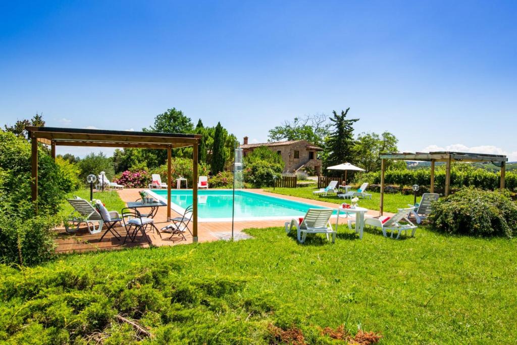 un patio trasero con piscina con sillas y cenador en Pietralta, en Gambassi Terme