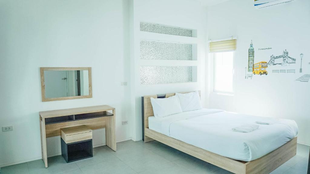 ein weißes Schlafzimmer mit einem Bett und einem Spiegel in der Unterkunft U pool villa Huahin in Hua Hin